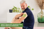 Man sitting and applying FlexiShoulder patch to his shoulder
