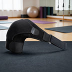 Black shoulder support brace on a yoga mat in a gym setting